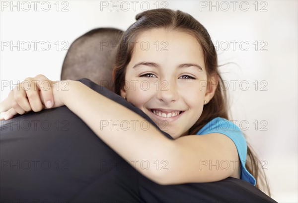 Father coming back from work embracing daughter (10-11). Photo : Momentimages