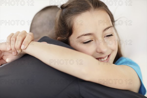 Father coming back from work embracing daughter (10-11). Photo : Momentimages