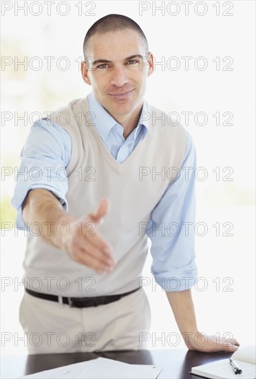 Mid adult man offering hand for handshake. Photo : Momentimages