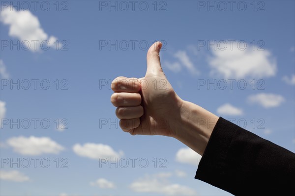 Young woman giving thumbs up. Photo : Johannes Kroemer