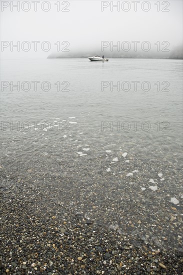 Boat near foggy beach. Photo : Johannes Kroemer