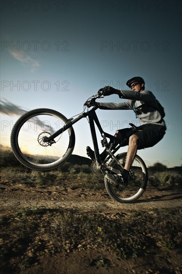 Man mountain biking on dirt track. Photo : Shawn O'Connor