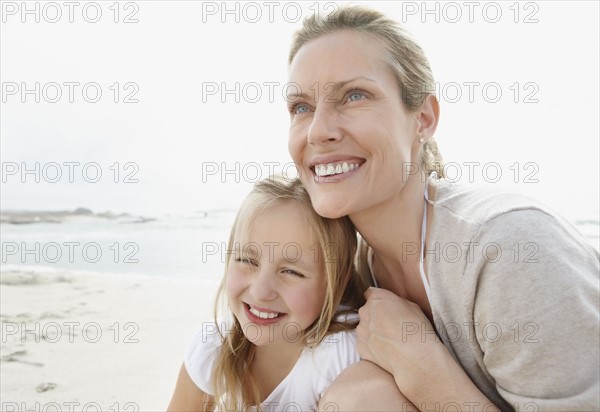 Girl (10-11) playing on beach with mother. Photo : Momentimages