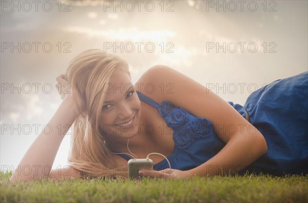 Young girl (16-17) lying on grass. Photo : Mike Kemp