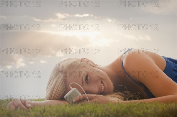 Young girl (16-17) lying on grass. Photo : Mike Kemp