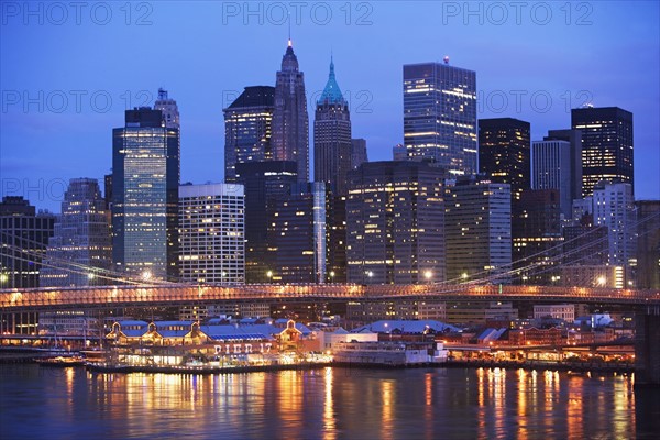 USA, New York State, New York City, Brooklyn Bridge and Manhattan skyline illuminated at dusk. Photo : fotog