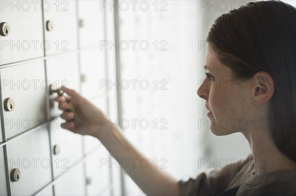 Woman opening mailbox.