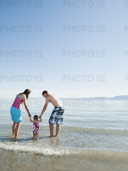 Parents with baby daughter (12-18months) playing on holidays.