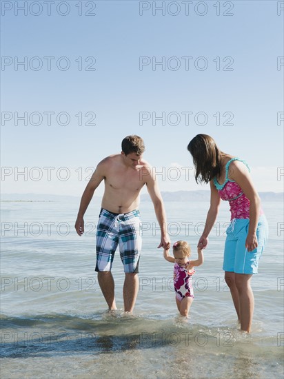 Parents with baby daughter (12-18months) playing on holidays.