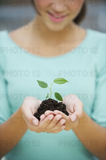 Girl (12-13) holding seedling.