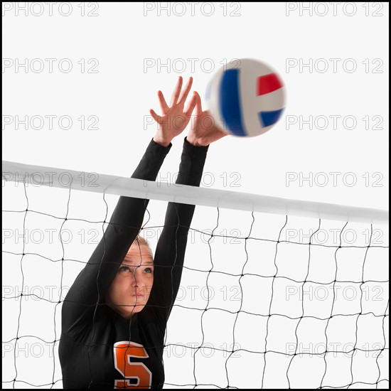 Young girl (16-17) playing volleyball. Photo : Mike Kemp
