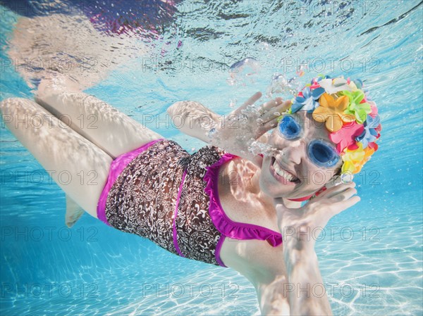 Girl (8-9) swimming underwater.