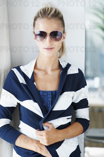 Portrait of young woman wearing striped blouse and sunglasses. Photo : Momentimages