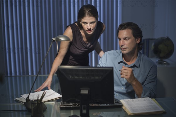 Man and woman working late in office.