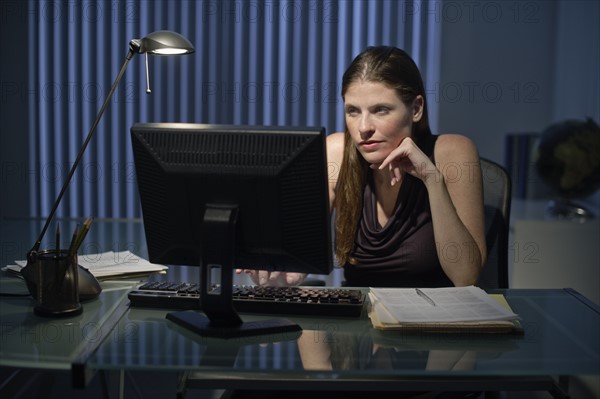 Woman working late in office.