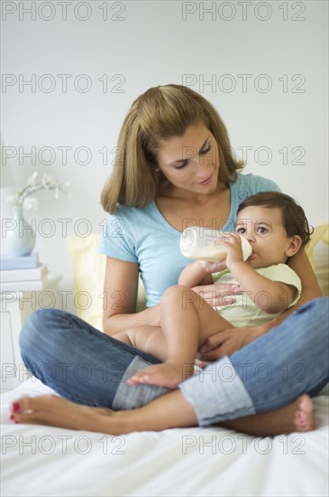 Mother feeding baby daughter (12-18 months) .