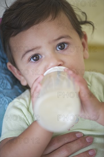 Mother feeding baby daughter (12-18 months) .