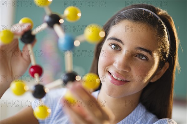Schoolgirl (12-13) looking at molecular model.