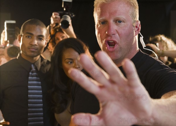 Bouncer shielding celebrity at red carpet event. Photo : Jamie Grill