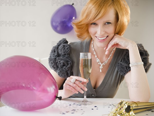 Young woman drinking champagne at party. Photo : Jamie Grill