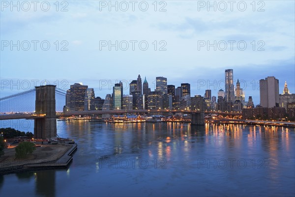 USA, New York State, New York City, Brooklyn Bridge and Manhattan skyline illuminated in early morning. Photo : fotog