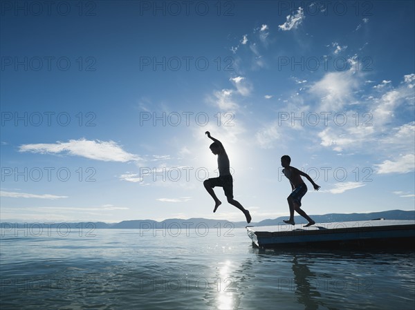 Boys (10-11,12-13) jumping from raft.
