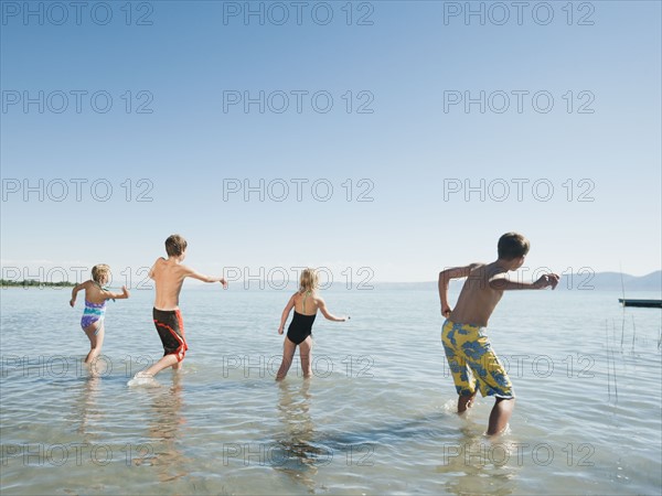 Kids (6-7,8-9,10-11,12-13) playing in lake.