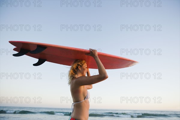 Portrait of woman with surfboard.