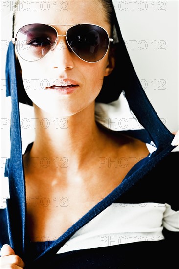 Portrait of young woman wearing striped blouse and sunglasses. Photo : Momentimages