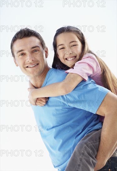 Father carrying daughter (10-11) on back. Photo : Momentimages