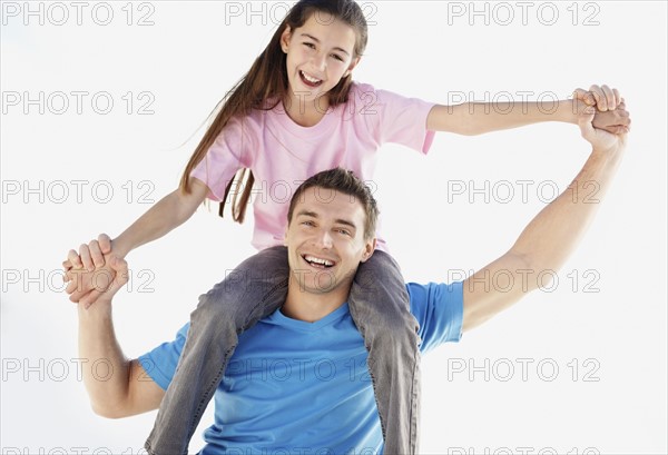 Father carrying daughter (10-11) on back. Photo : Momentimages