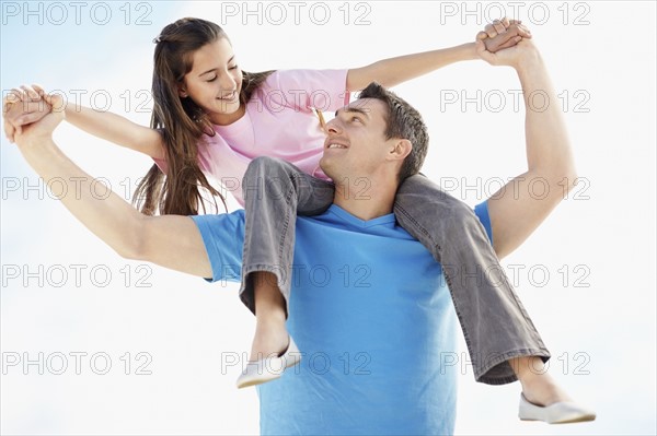 Father carrying daughter (10-11) on back. Photo : Momentimages