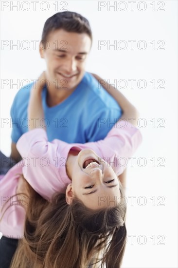 Father playing with daughter (10-11) . Photo : Momentimages