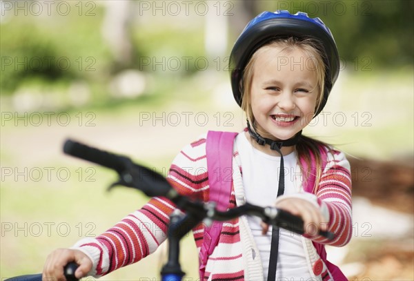 Smiling girl (10-11) with bicycle. Photo : Momentimages