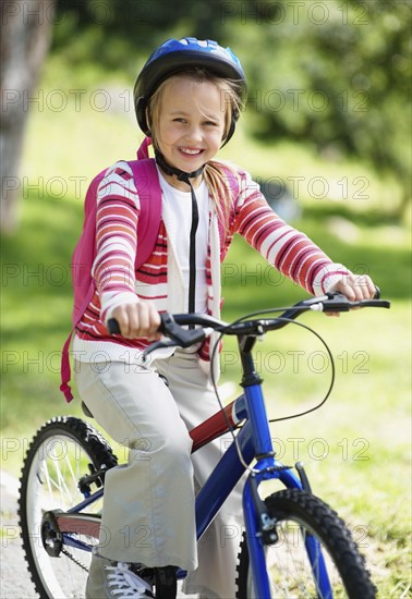 Smiling girl (10-11) with bicycle. Photo : Momentimages