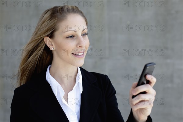 Businesswoman using mobile phone. Photo : Johannes Kroemer