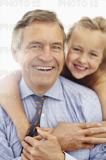 Portrait of smiling grandfather and granddaughter (10-11). Photo : Momentimages