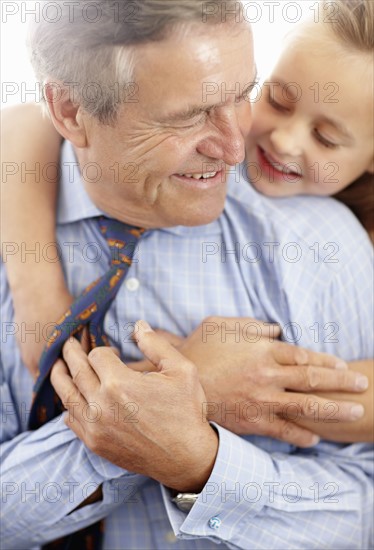 Grandfather and granddaughter (10-11) hugging. Photo : Momentimages