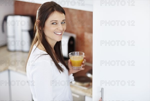 Portrait of mid adult woman holding glass. Photo : Momentimages