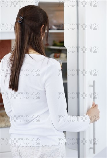 woman opening fridge. Photo : Momentimages