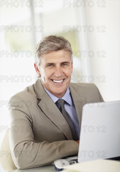 Portrait of businessman with laptop. Photo : Momentimages