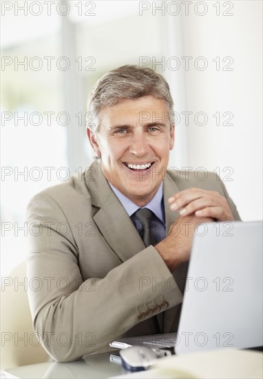 Portrait of businessman with laptop. Photo : Momentimages