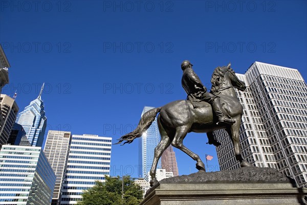 USA, Pennsylvania, Philadelphia, Statue depicting man on horse, skyscrapers in background. Photo : fotog