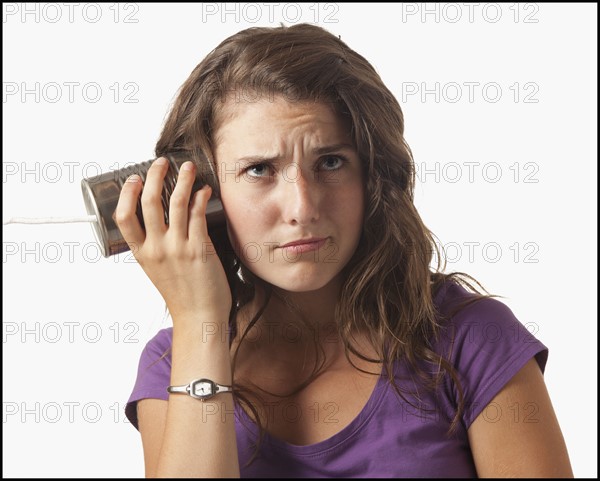 Young woman holding tin can phone. Photo : Mike Kemp