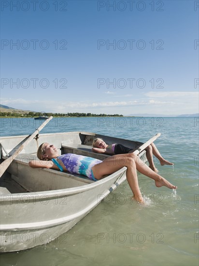 Girls (6-7,8-9) resting on boat.