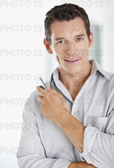 Portrait of good-looking mid adult man with mobile phone. Photo : Momentimages