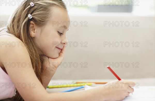 Girl (10-11) doing homework. Photo : Momentimages