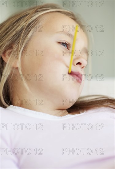 Girl (10-11) checking temperature with thermometer. Photo : Momentimages