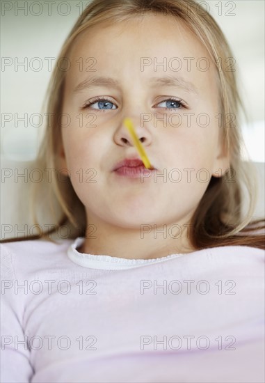 Girl (10-11) checking temperature with thermometer. Photo : Momentimages