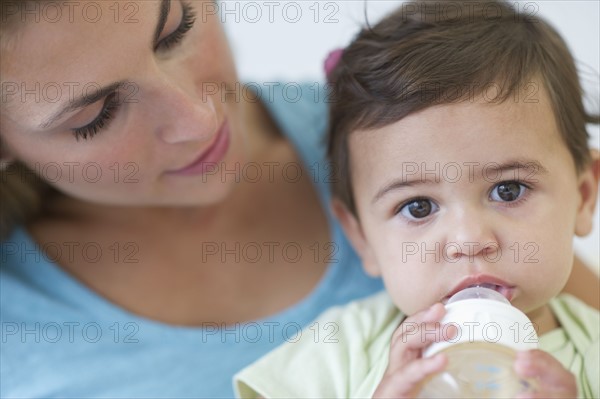 Mother feeding baby daughter (12-18 months) .